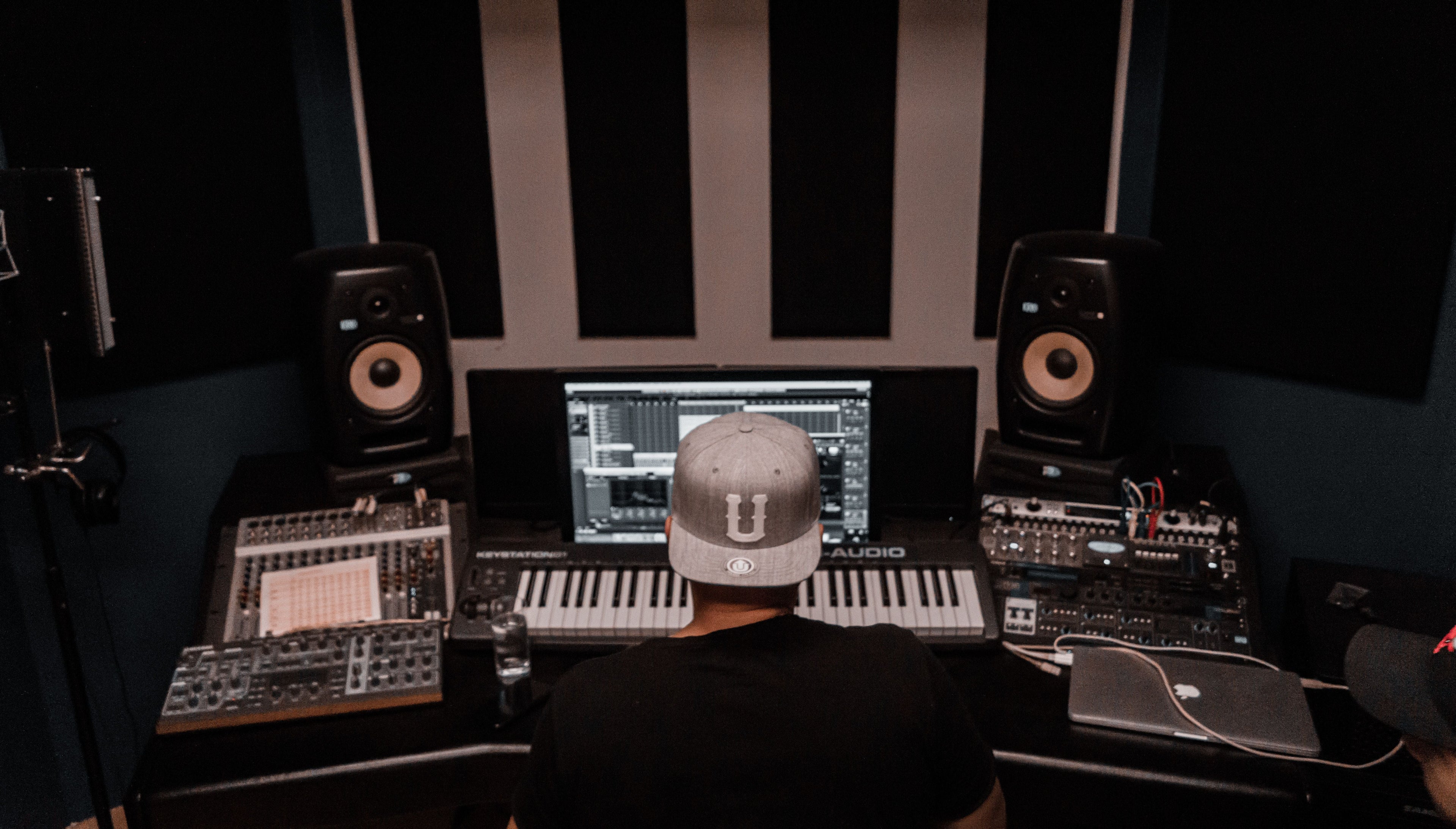 Music producer working in a modern studio with keyboards and monitors for a custom Afrobeat beat